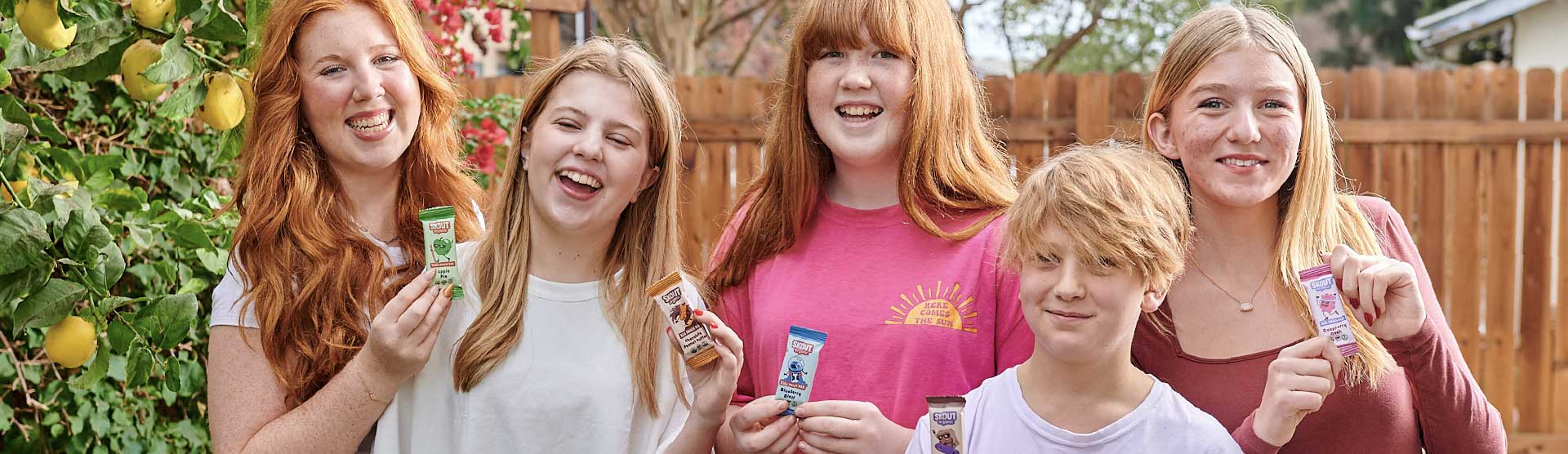 Group of smiling kids outside holding Skout Organic Kids Snack Bars