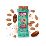 Skout Organic Almond Cookie Kids Snack Bar in an open wrapper, surrounded by dates, almonds, and Himalayan pink salt.