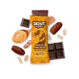 Skout Organic Chocolate Peanut Butter Kids Snack Bar in an open wrapper, surrounded by dates, peanut butter, and peanuts.