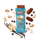 Skout Organic Cookie Dough Kids Snack Bar in an open wrapper, surrounded by dates, chocolate chips, vanilla, and Himalayan pink salt.