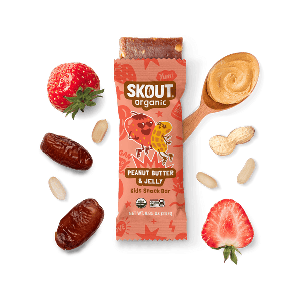 Skout Organic Peanut Butter & Jelly Kids Snack Bar with open wrapper and bar showing, surrounded by dates, peanuts, and strawberries