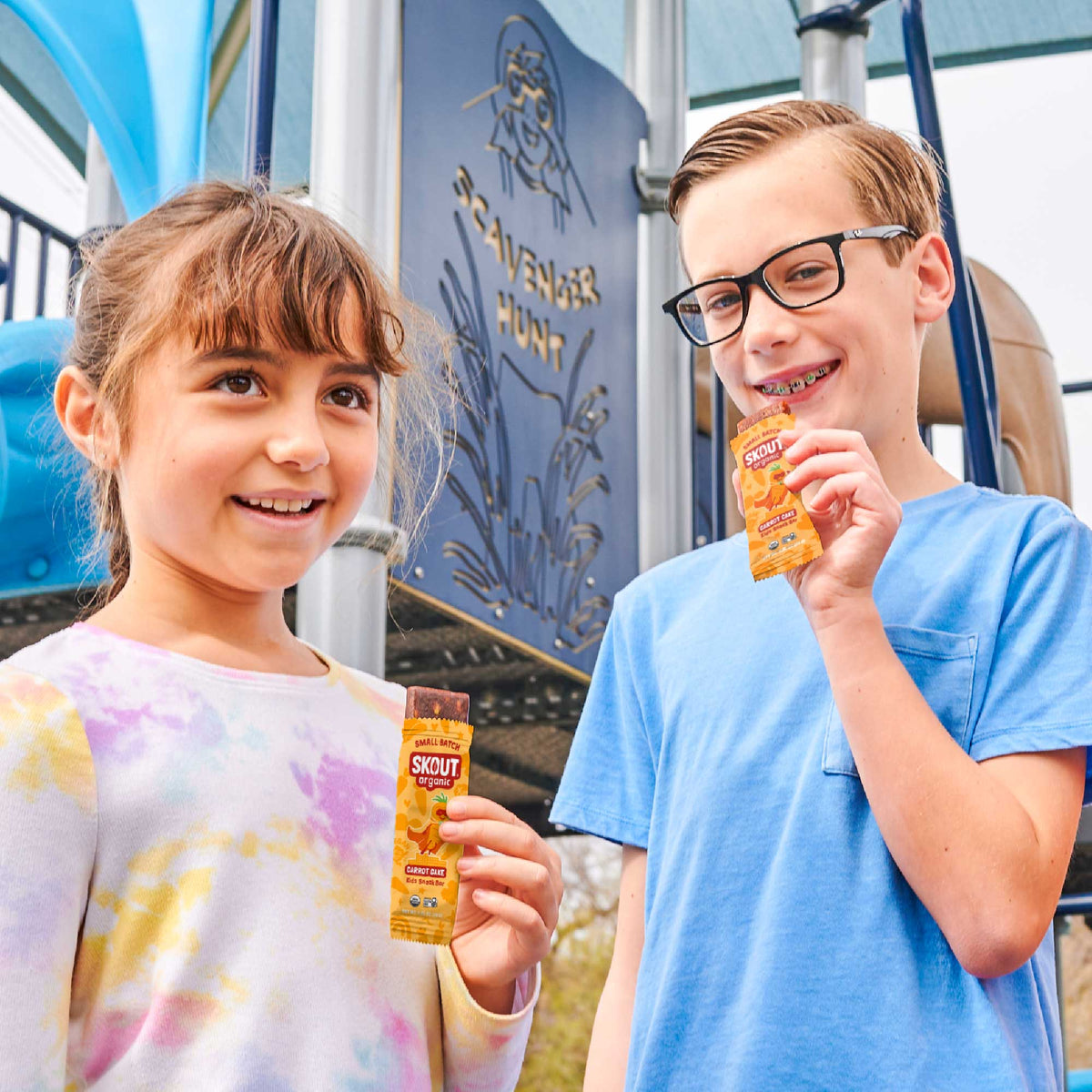Two kids enjoying Skout Organic Carrot Cake Kids Snack Bars at a playground