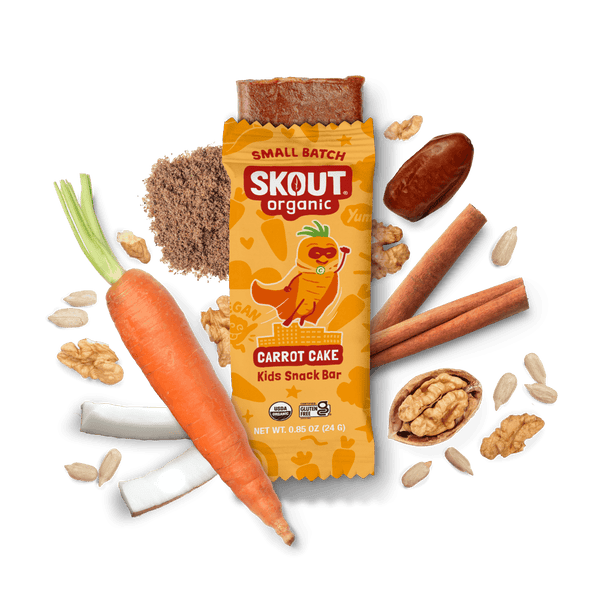 Skout Organic Small Batch Carrot Cake Kids Snack Bar with open wrapper and bar showing, surrounded by dates, carrots, walnuts, and cinnamon sticks