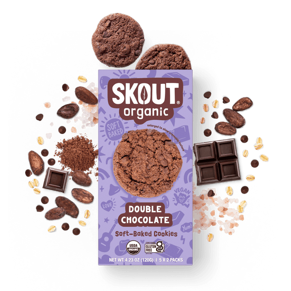 Skout Organic Double Chocolate Soft-Baked Cookies in an open box, surrounded by cocoa powder and chocolate chips.