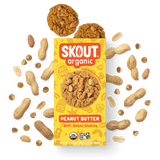 Skout Organic Peanut Butter Soft-Baked Cookies in an open box, surrounded by peanuts and peanut butter chips.